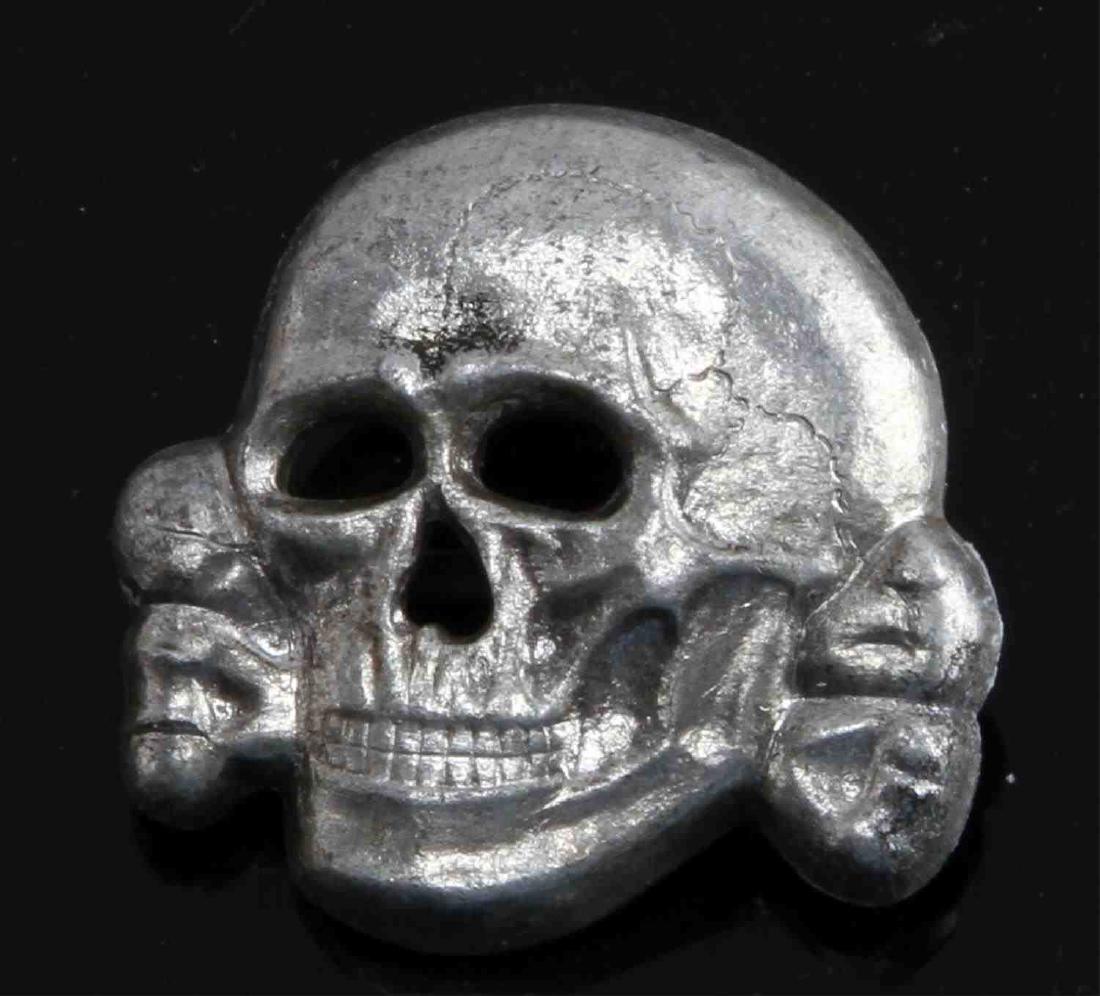 GERMAN WWII TR WAFFEN SS OFFICERS CAP SKULL: Reverse is marked " "RZM M1/52". Has 2 flat brass horizontal prongs. Stamped nickel construction. Overall in very good condition. Unauthenticated, sold as.