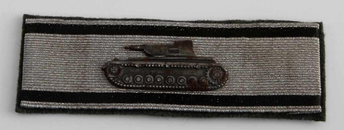 WWII GERMAN 3RD REICH ARMY TANK DESTRUCTION BADGE: Tank destruction badge in silver. Measures 4 inches wide by 1 5/16 inches tall. The front shows a profile of a Panzer IV tank. It is mounted onto a flat silver bullion wire strip. Has a green wool bac