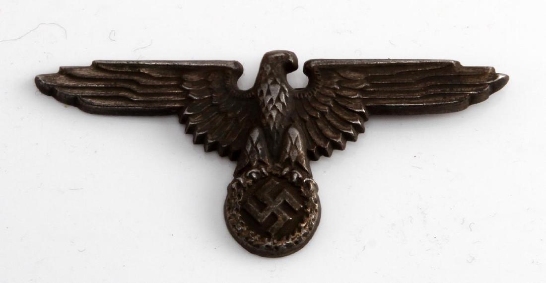 WWII GERMAN THIRD REICH SS OFFICER VISOR CAP EAGLE: Eagle badge from the visor cap of a Waffen SS officer. The reverse is marked 'RZM M1/79', Has one horizontal prong on the reverse side. Stamped nickel construction. Very good condition.