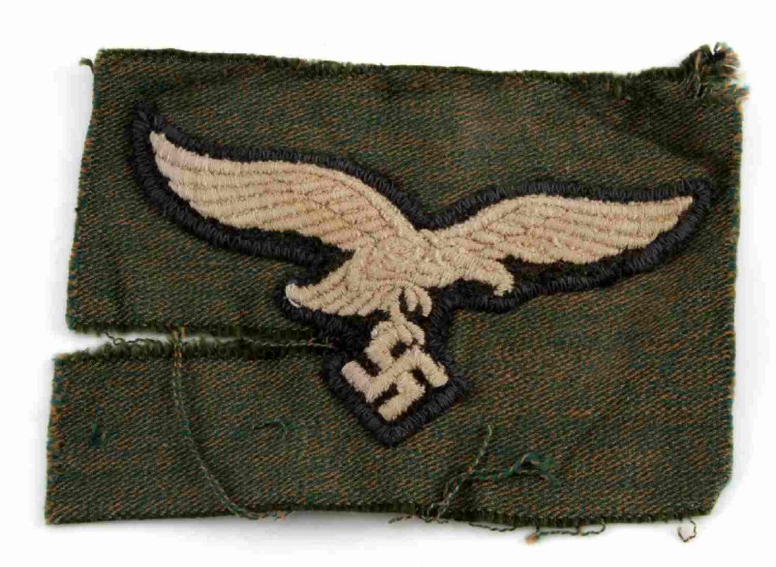GERMAN WWII LUFTWAFFE PARATROOPER SMOCK EAGLE: German WWII Luftwaffe Paratrooper Fallschirmjager Smock Breast Eagle. Measures 4 x 2 3/4 inches. Cut from a paratrooper's smock. Machine embroidered and sewn with a zig zag stitch. Rare. Unauthenticat