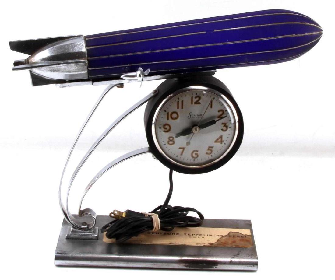 WWII DEUTSCHE ZEPPELIN SESSIONS GERMAN DESK CLOCK: Markers label intact, with some water staining, reads Deutsche Zeppelin-Reederei G.m.b.H. next to German flag. It appears to have had some restoration over the years, cord from 1950's, chrome on under