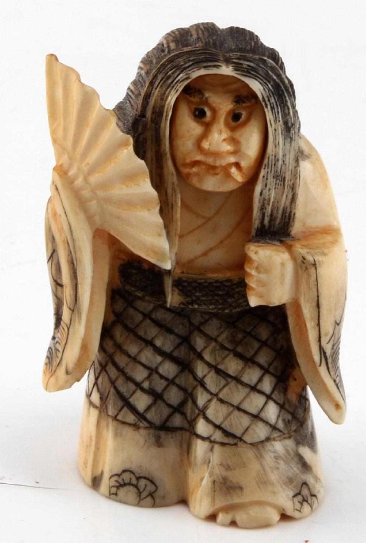 VINTAGE JAPANESE WALRUS TUSK NETSUKE FIGURE: Japanese netsuke figurine carved from walrus tusk. Resembles an old woman with a fan. Face can spin to present either a happy or angry face. Measures 2 inches in height and weighs 34 grams. In very go