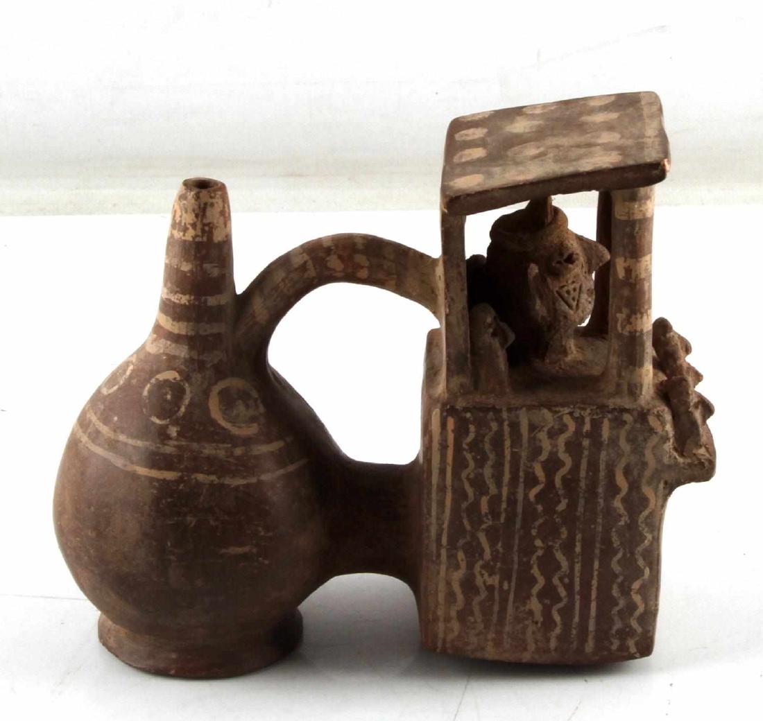 ANTIQUE NATIVE AMERICAN DECORATIVE CERAMIC JUG: Ceramic jug of Native American make. Includes six figures underneath a structure attached to the pot. Piece measures roughly 5.5 x 3 x 3 inches. In very good condition.