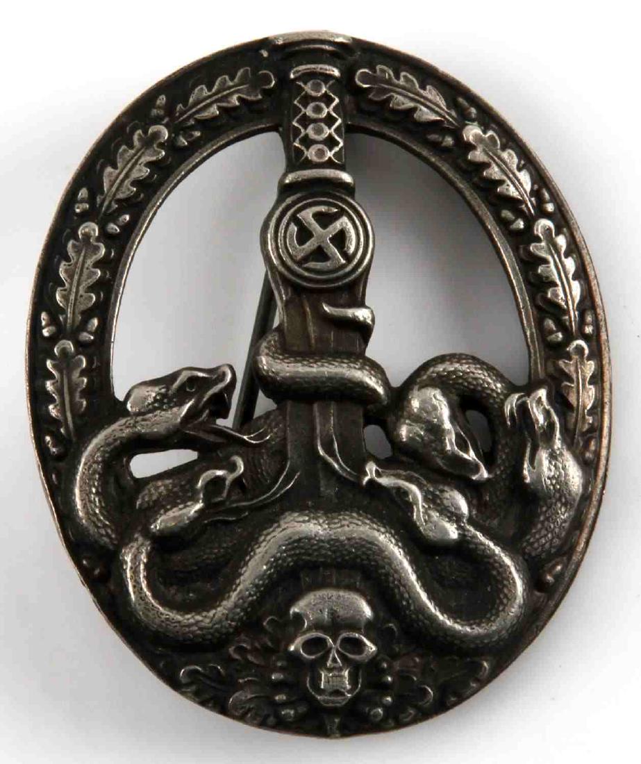 GERMAN WWII ANTI PARTISAN BADGE SILVER 2ND CLASS: German WWII Anti-Partisan Badge in Silver. Partial open oak leaf wreath holding a relief sword/sun-wheel swastika, intertwined snakes and a skull/crossbones. Fine detailed badge has a nice aged patina