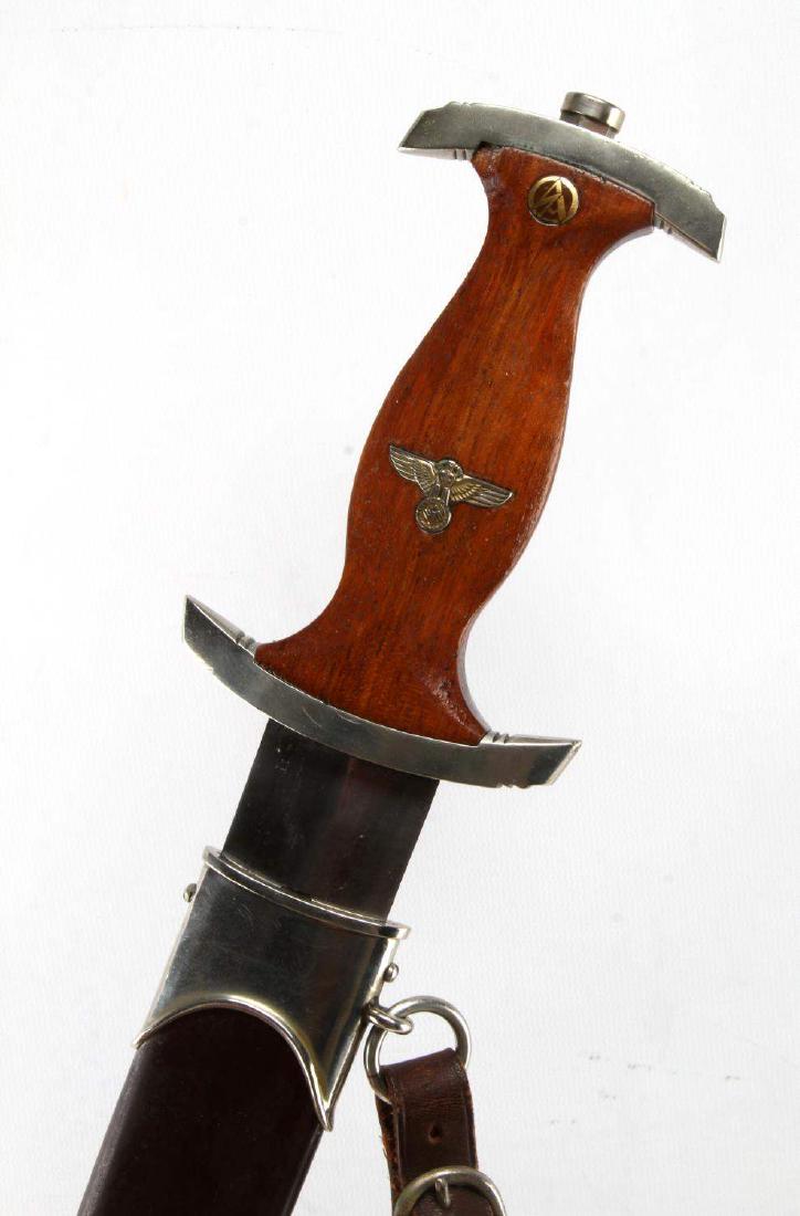 WWII GERMAN THIRD REICH SA EM DAGGER W/ SHEATH: SA enlisted man dagger with brown painted sheath. Has lighter colored wooden grip. The back of the blade is marked 'Wilh. Kober & Co SUHL' and the guard is marked 'Th'. The grip is chipped just below 