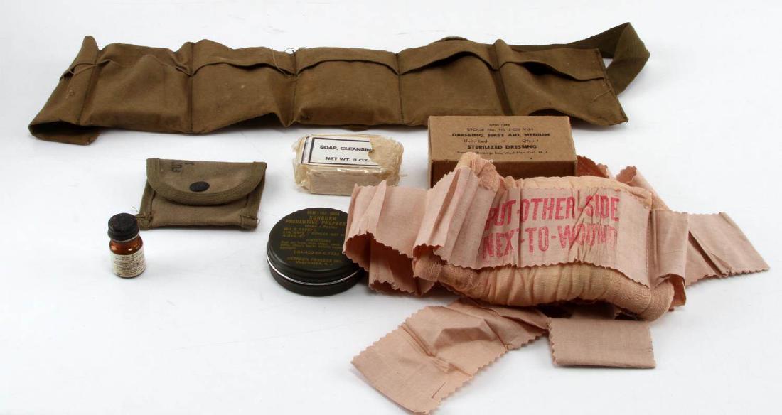 WWII AND COLD WAR US ARMY FIELD FIRST AID GEAR: Includes a WWII era medium first aid field dressing in box, an unboxed larger sized field dressing, Vietnam era sunburn preventitive preparation cream paste in tin, a WWII era bottle of 50 water purif