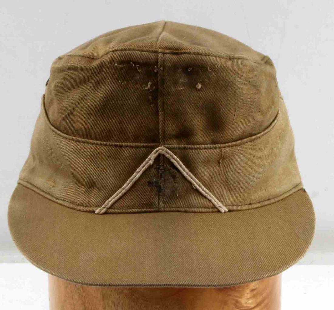WWII GERMAN THIRD REICH KHAKI TROPICAL M43 CAP: M43 field cap in tropical khaki. Has had the Reichsadler and cockade badges removed. Has a white piping triangle around where the cockade goes. In generally good condition. Stamped '2819 0027 41 58' i