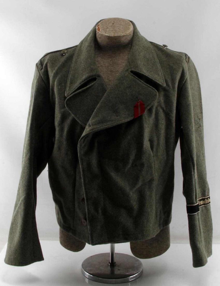 WWII GERMAN THIRD REICH SS PANZER EM WRAP: A feldgrau panzer wrap with a cuff title of the 10th SS Panzer Division Frundsberg. Most of the patches and collar tabs appear to have been removed, but an Eastern Front medal is tucked into the secon