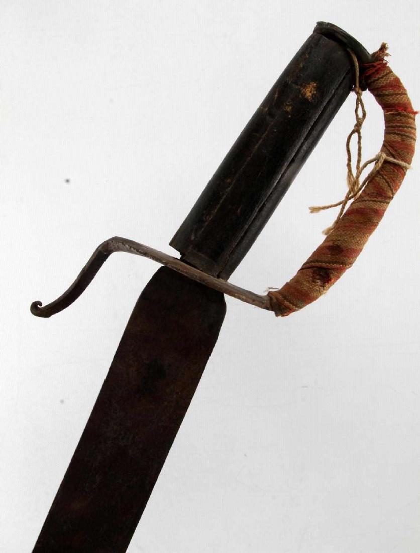 ANTIQUE IRON GUARD NAVAL CUTLASS SHORT SABER: Antique naval cutlass with an iron guard and wooden grip. Has a colorful cloth wrap around the knuckle bow. Measures 30 1/2 inches overall. In very good condition. Minor nicks on the sharpened blade,