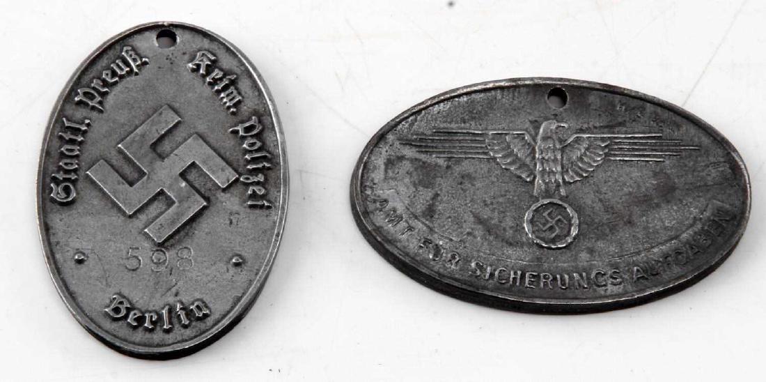 2 WWII GERMAN SECRET POLICE IDENTIFICATION TAG LOT: Lot of TWO (2) includes SS Police of Danzig and Prussian State Police (Berlin Department). Some wear. Tags measure approx. 2 inches each. Unauthenticated. Sold "as is".