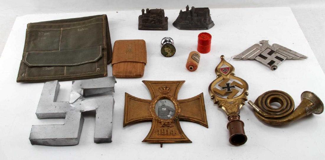 WWII THIRD REICH GERMAN MEMORABILIA FINIAL MORE: Mixed lot includes: military bag, flag topper, Nazi finial, aluminum swastika, Nurnberg figures, Grusse aus der Helmat cigarette case, mini brass Nazi French horn, 1914 bronze iron cross frame with ph