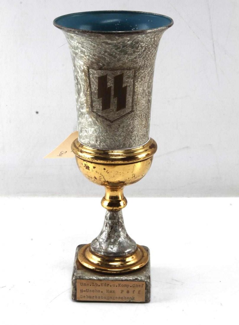 WWII GERMAN THIRD REICH WAFFEN SS PRIZE CUP: Writing on the plaque of the cup states that it was awarded as a geburtstagsgeschenk or birthday present. The cup features the SS emblem on the front and measures 10" in height. Cup shows signs of use