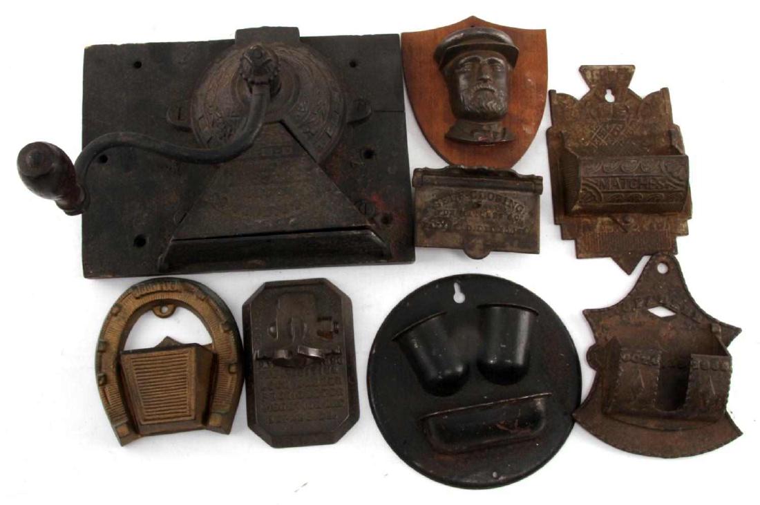 ANTIQUE CAST IRON ADVERTISING WALL HANGER LOT OF 8: Lot contains 8 antique wall hanging devices. Includes a coffee grinder, five match safes of various styles, a hanger, and a self-closing ash tray. All are in generally good condition, with minor surfa