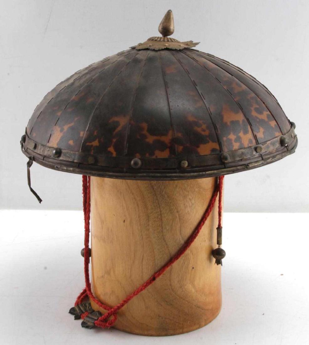 ANTIQUE CHINESE TORTOISE SHELL SEGMENT HELMET: Helmet made of 20 strips of tortoise shell formed into a dome. Believed to be of Chinese origin. Brass with a red cord strap. Measures about 12 inches wide by 5 inches in height. In very good conditio