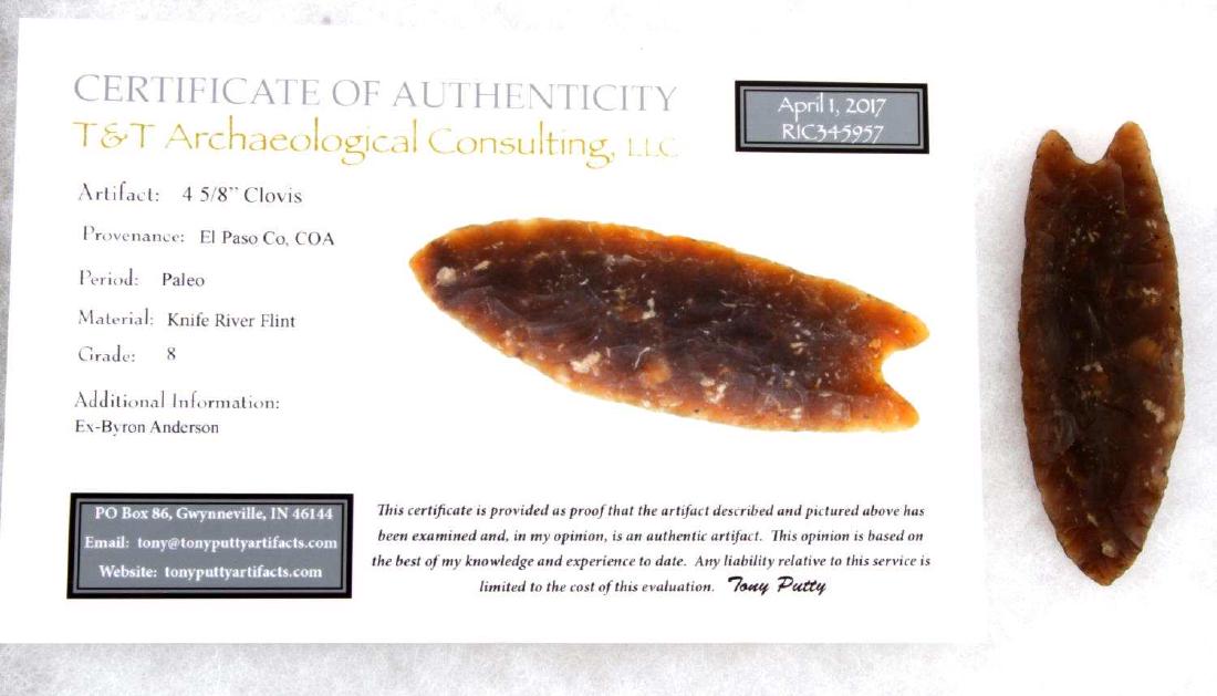 PALEO LITHIC CLOVIS POINT ARROWHEAD W COA: This 4 5/8 inch Clovis point is composed of Knife River flint, is medium-large size, auriculate, and fluted, with concave ground base with ears. It comes with certificate of authenticity, is graded 8,
