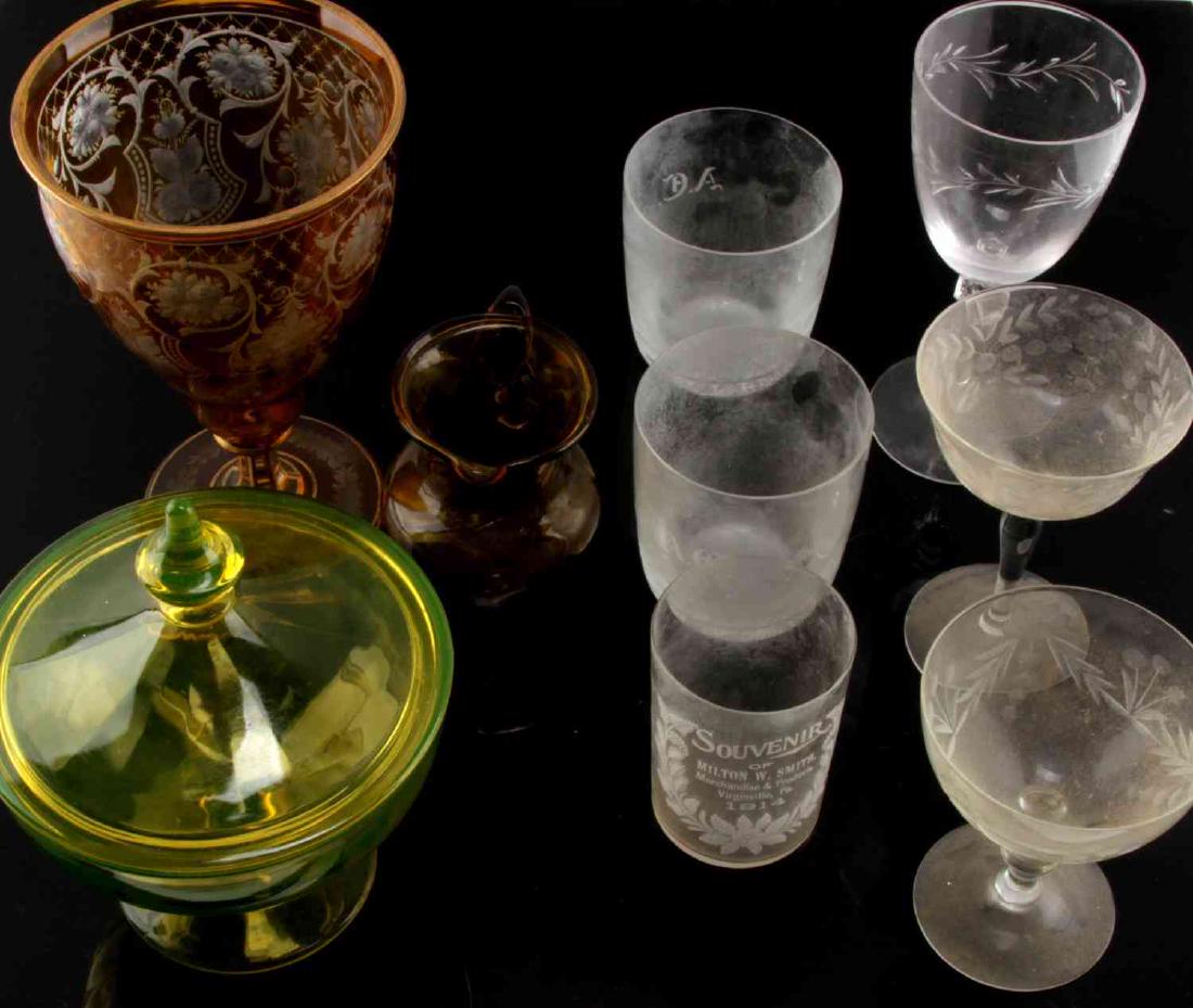 LOT OF 9 ASSORTED ANTIQUE GLASSWARE AND STEMWARE: Lot includes: 1 large etched orange glass goblet, 2 glasses marked A.C., 1 glass marked Milton W. Smith Virginville, PA. 1914, 1 small yellow and brown glass pitcher, 3 pieces of unmarked stemware win