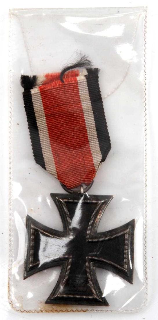 GERMAN WWII ERNST L MULLER 76 IRON CROSS W RIBBON: A scarce Ernt L. Muller of Pforzheim made iron cross 2nd class. With its original presentation ribbon. Ring stamped '76'. Sandwich crease present all around. Core fully magnetizes and shows iron core.