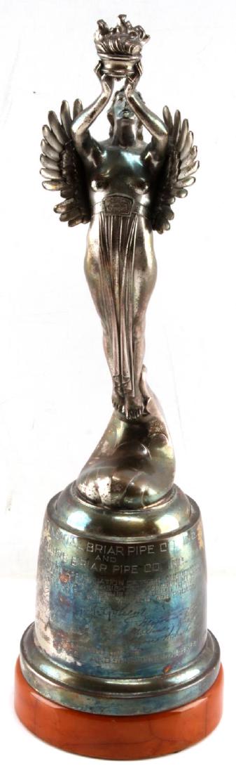 VINTAGE ART DECO COMPANY MERGER CELEBRATORY TROPHY: Trophy featuring an art deco style winged angel holding a brazier. Seems to be made of nickeled aluminum, with some of the nickel finish flaked off. Has a caramel colored bakelite base. Plinth of the 