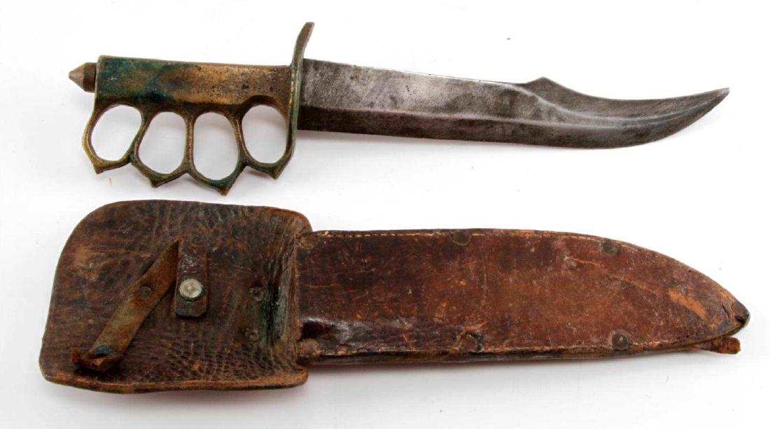 US WWI KNUCKLE DUSTER TRENCH KNIFE WITH SHEATH: U.S. WWI era "knuckle duster" trench knife. Unmarked exterior. Features a 9" blade that shows minor tarnishing. Scarce variant. With unoriginal leather sheath. VG condition. UEW 148.
