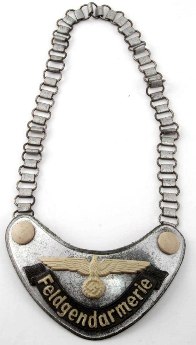 WWII GERMAN THIRD REICH FELDGENDARMERIE GORGET: Feldgendarmerie gorget. Has an 'A' stamp on one of the hooks. Includes minor corrosion and scratching on the surface. In good condition overall. Luminesces in the dark. FE100