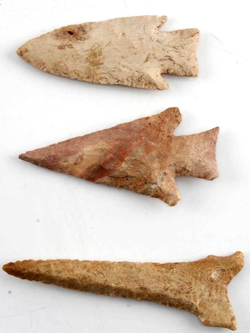 LOT OF 3 ARROWHEAD POINTS CREAM TO PINK FLINT: Lot includes: one triangular pink FLINT point with worn edges and ground base, one spindly point with glossy finish and beveled edge, and one cream color point with worn patina and broad base. Measure