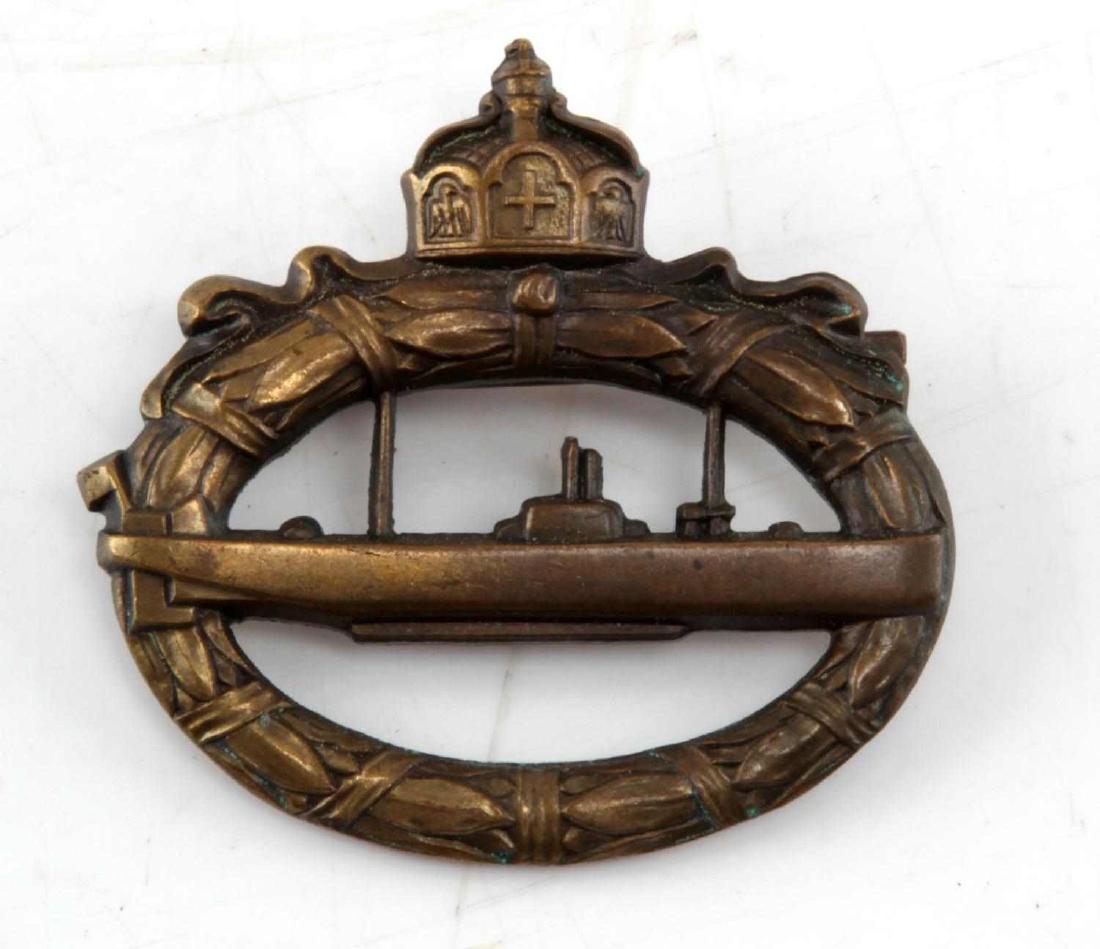 WWI IMPERIAL GERMAN EM U BOAT BADGE IN BRONZE: An Imperial German U-boat medal. Features a wreath of oak leaves encompassing a submarine. The rear is marked with "WALTER SCHOTT, fec". It has a horizontal broad pin with "C" clasp. Measures 2 X 2 in