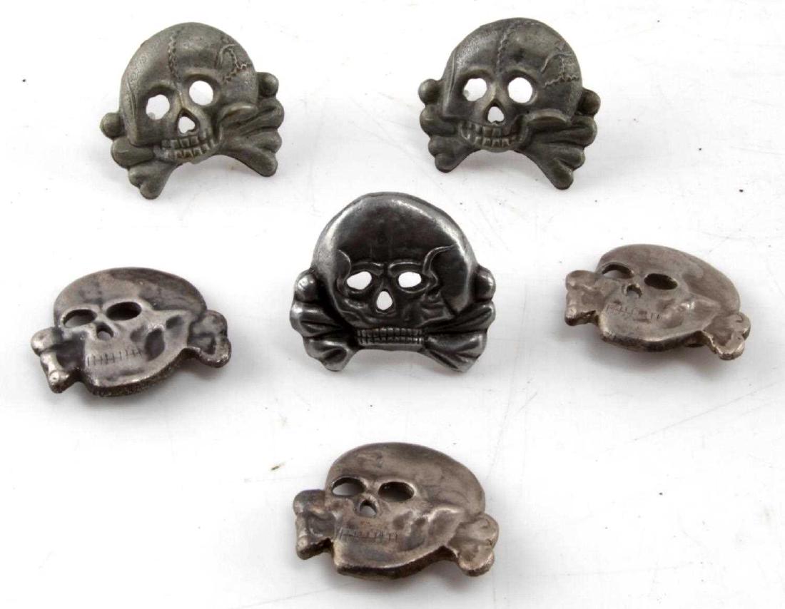 WWII GERMAN THIRD REICH SS TOTENKOPF CAP BADGE LOT: Lot contains 6 Totenkopf cap badges, including 3 'toothless' panzer variation badges. In very good condition. Unauthenticated/Sold 'as is' This lot has a reserve.