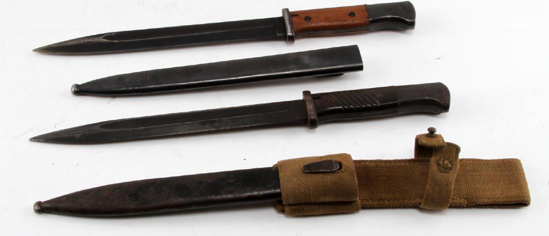 WWII K98 BAYONET LOT OF 2 1 NEAR MINT: Near mint blackened blade without frog and no serial number on scabbard, scabbard is dented. A second with web frog, blackened blade and bakelite grip all very good. EW91, EW108.