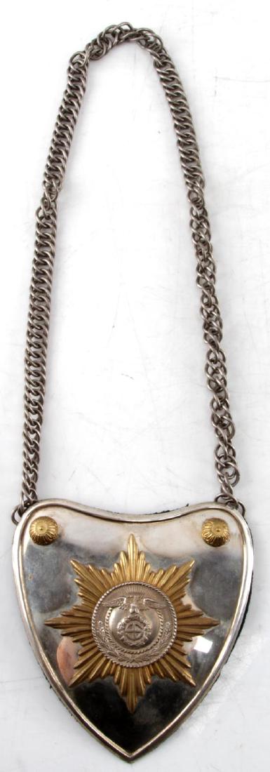 WWII GERMAN THIRD REICH SA STANDARD BEARER GORGET: SA/SS heart-shaped gorget. Brass relief eagle/sun wheel swastika on center panel affixed to a gilt sunburst – mounted on a convex nickeled shield. Gold bosses in corners. Reverse covered in blue clo