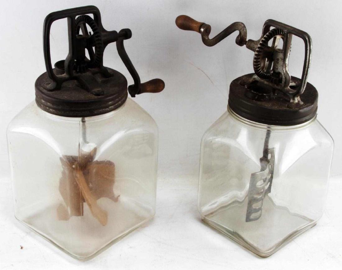 LOT OF 2 ANTIQUE LARGE GLASS BUTTER CHURNS: Lot of two (2) large glass butter churns. First is a large four (4) quart Dazey Churn number 40 glass butter churn with an aluminum paddle. Second is a large six (6) quart glass butter churn with a wo