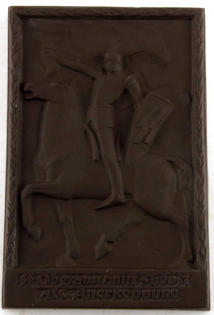 WWII GERMAN 3RD REICH SS KNIGHT RECOGNITION PLAQUE: Recognition plaque of the SS-Oberabschnitt Südost. Depicts a mounted figure weilding a shield with the SS sig runes on it and carrying a swastika banner. Fired ceramic construction. Measures 6 1/4 by