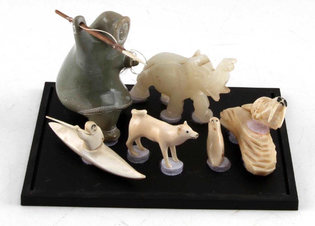 NATIVE ALASKAN INUIT BONE & SOAPSTONE CARVINGS: Native American Alaskan Inuit Bone & Soapstone handmade carvings of seal, wolf, walrus, and Inuit hunter with spear on kayak, also present is a white jade elephant carving, with the largest carving of