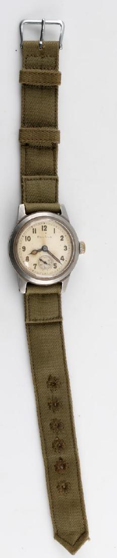 WWII US BULOVA WRIST WATCH SILVER FACE OLIVE BAND: A WWII US Bulova wrist watch. Silver face on an olive green canvas band. Some light scratching around watch face rim, canvas band in excellent condition. Measures approximately 9.25 inches in length.