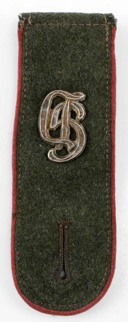 WWII GERMAN HEER GROSSDEUTSCHLAND SHOULDER BOARD: Slip-on shoulder board of a Großdeutschland Division Panzer crew enlisted man. 1 13/16 inches wide by 9 7/8 inches long. The front has the cypher of the division in nickel upon it. In very good condi