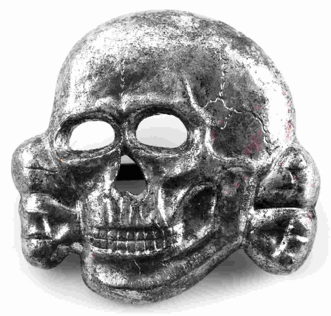 WWII GERMAN WAFFEN SS VISOR TOTENKOPF SKULL: German Schutz Staffel Officers Kepi/visor cap totenkopf. This version has a lower jaw and two flat horizontal prongs on the reverse. Stamped silver plated copper construction. Measures 1 5/16 X 1 3/16