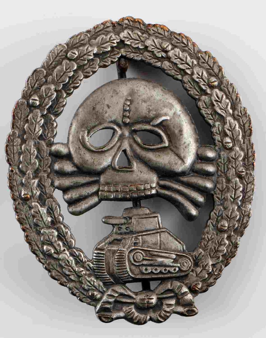 WWII GERMAN CONDOR LEGION TANK ASSAULT BADGE: WWII German Spanish Condor Legion Panzer Assault badge. Totenkopf and panzer within oak leaf wreath. One piece stamped nickel construction. Thin vertical pin back with "c" catch. Very good condition o