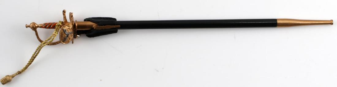 GERMAN WWII THIRD REICH MINIATURE GENERAL SWORD: German WWII Luftwaffe miniature general sword and scabbard. Measures about 5 inches long and 3/16 inch wide. Constructed with brass D-guard, leather belt hanger, and gold bullion sword knot. Very good