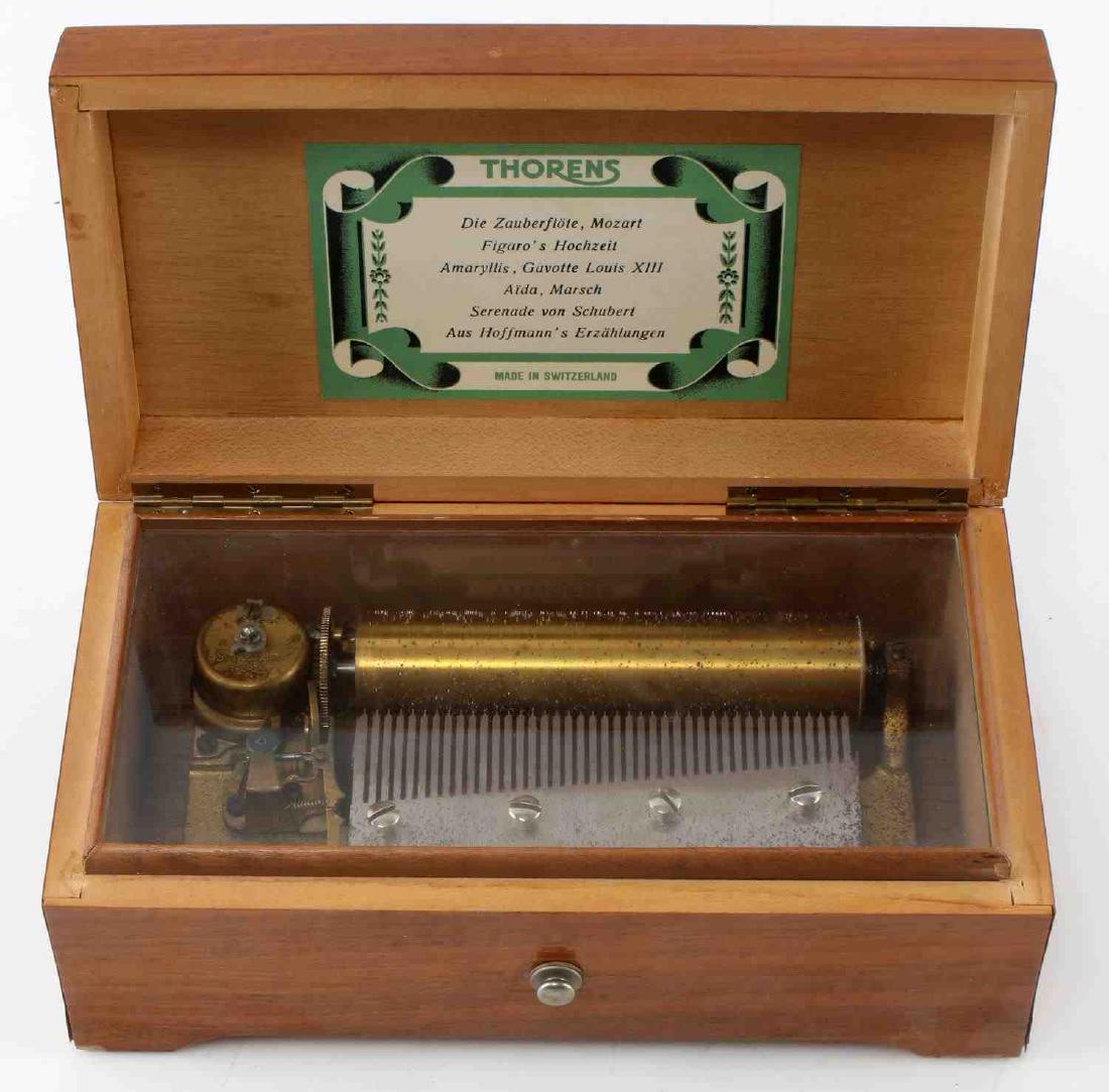 THORENS 4 SONG WOOD BOX MUSIC BOX SWISS MADE: God working condition, measures 8 by 3 by 4 1/2 inches.