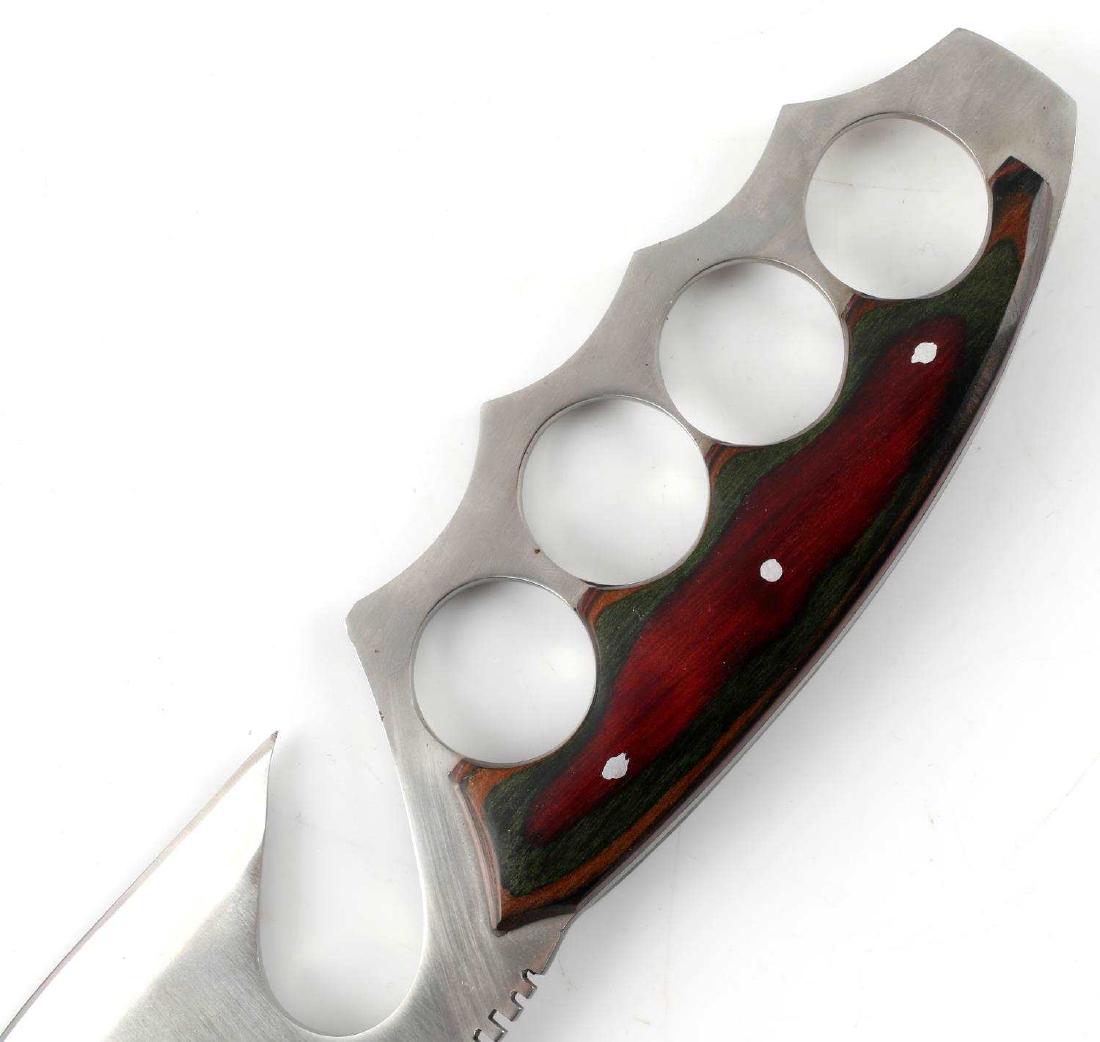 SHEATHED EXOTIC FIGHTING KNIFE W KNUCKLE DUSTER: 11-inch long Exotic Fighting / Hunting Knife with knuckle dusters, gut-hook, and curved blade with serrated upper spine and grip. Item is in like-new condition with original embossed black sheath, bla