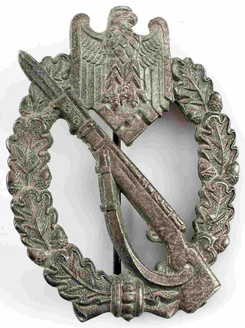 WWII GERMAN THIRD REICH INFANTRY ASSAULT BADGE: German Infantry Assault Badge. Reichsadler clasping swastika at the top of an open oak leaf wreath holding a rifle with a fixed bayonet. Some traces of silver remain. Reverse marked "GWU" within circl