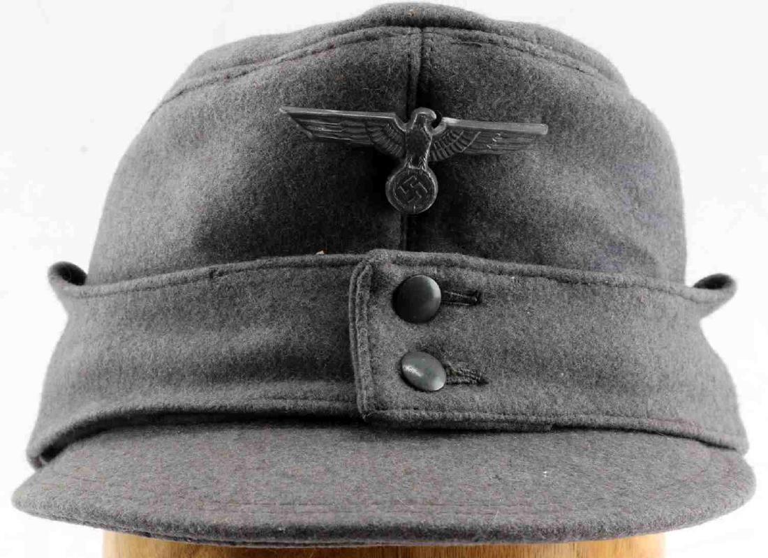 WWII GERMAN THIRD REICH M43 HEER FIELD CAP: This is German Heer M43 field cap. Wool construction with Reichsadler hat badge intact leather lining. Marked "TOTAL Feuerschutz Dusseldorf KS-NW" on the interior. Very good condition overall with som