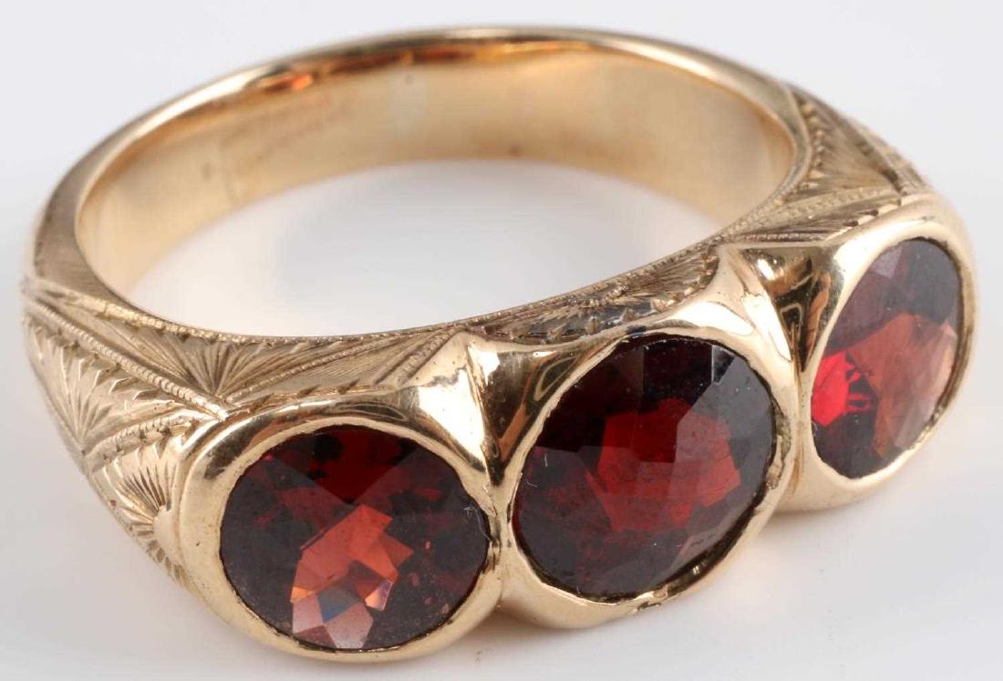 14K GOLD MENS RING THREE GARNET STONES VICTORIAN: Victorian men's ring. 14k gold. Has three garnet stones and etched design surrounding. Size 11. 14.35 grams. In good condition. This lot has a reserve.