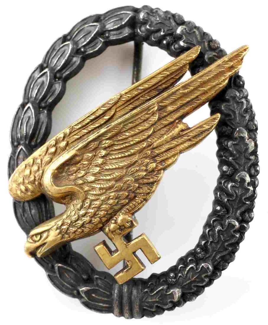 WWII GERMAN FALLSCHIRMJAGER PARATROOPER BADGE: German Fallschirmjager badge. 2 piece domed rivet construction with thin vertical pin back. Marked C.E. Juncker Berlin SW on reverse. Excellent collectors condition with great detail. Very minor signs