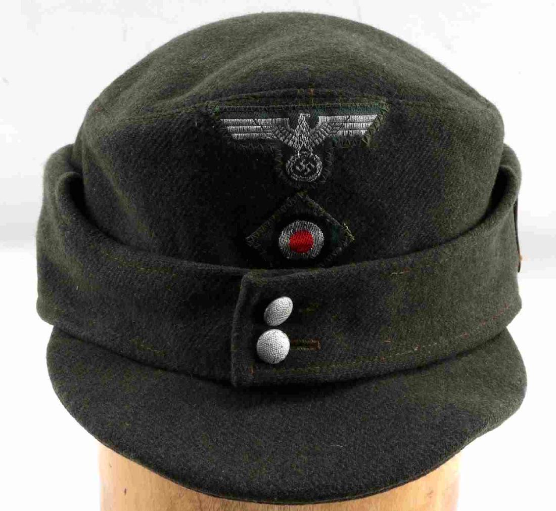 WWII GERMAN THIRD REICH M43 MOUNTAIN TROOP CAP: German Army M43 Gebirgsjaeger Mountain troop cap. Green wool with Bevo cloth Reichsadler and roundel. Metal edelweiss badge sewn on the left side. Size stamped '58' above 'BBN/7242/3848'. In very good