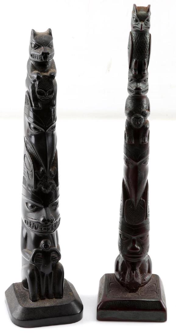 LOT TWO SMALL BLACK WOOD & RED WOOD TOTEM POLES: Lot two small hand carved totem poles. One black wood measuring 11.25 inches tall. One red wood measuring 12 inches tall. Both in very good condition and unsigned.