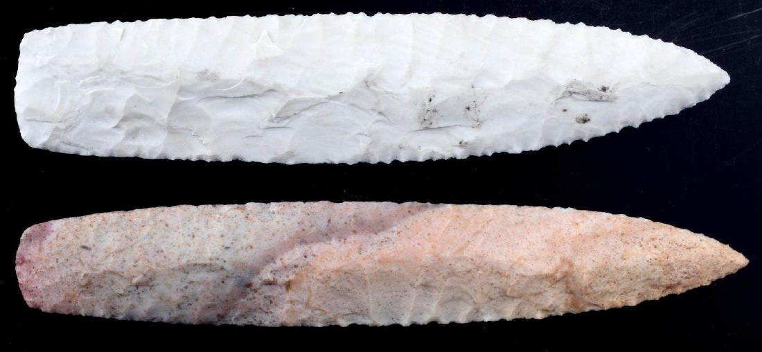 LOT OF 2 ARROWHEAD POINTS WHITE AND PINK CHERT: White point has broad flaking to one side and more collateral flaking to the other, 5.75 inches long. The pink one has gradations of color and parallel flaking, 6 inches long. Very good condition.