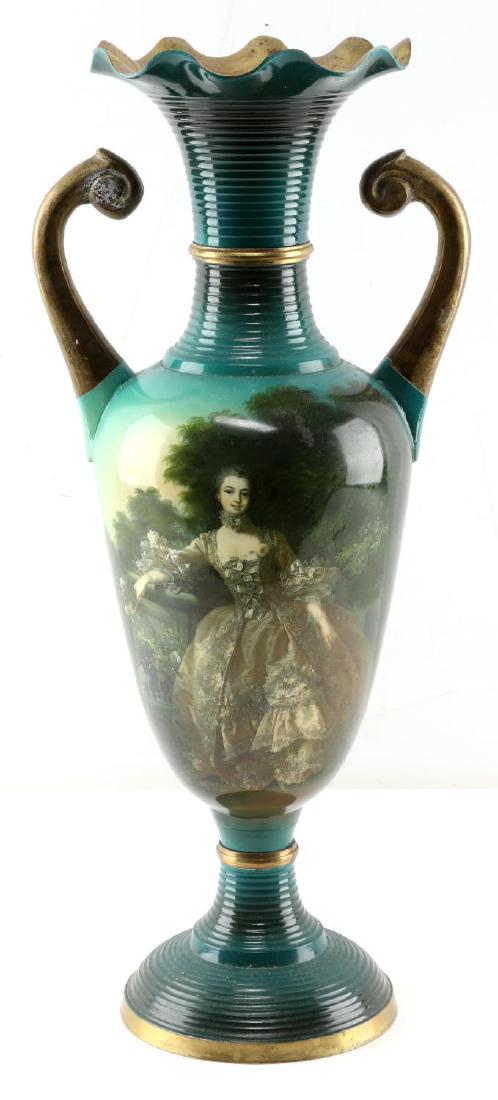 ENAMELED DECORATIVE BRASS FRENCH ROCOCO STYLE VASE: Enameled decorative brass French rococo style vase. Enamel shows a French rococo woman holding a fan in landscape. Has two handles. In good condition. Measures approximately 18.5 inches by 7.5 inches.