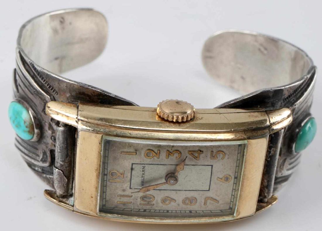 ETCHED SILVER TURQUOISE BANGLE WALTHAM WATCH FACE: Open silver bangle etched with eagle and arrow on each side. Small oval turquoise on each side. Attached Waltham watch face. Working condition.