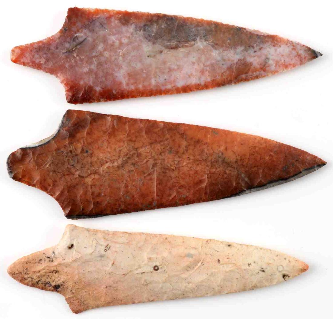 LOT THREE PUTNAM ARROWHEAD POINTS FLORIDA CORAL: Orange pink Florida coral Putnam arrowhead point. Broad parallel flaking. Measures 7 inches. In very good condition. Dark orange Florida coral Putnam arrowhead point. Broad parallel flaking. Measures