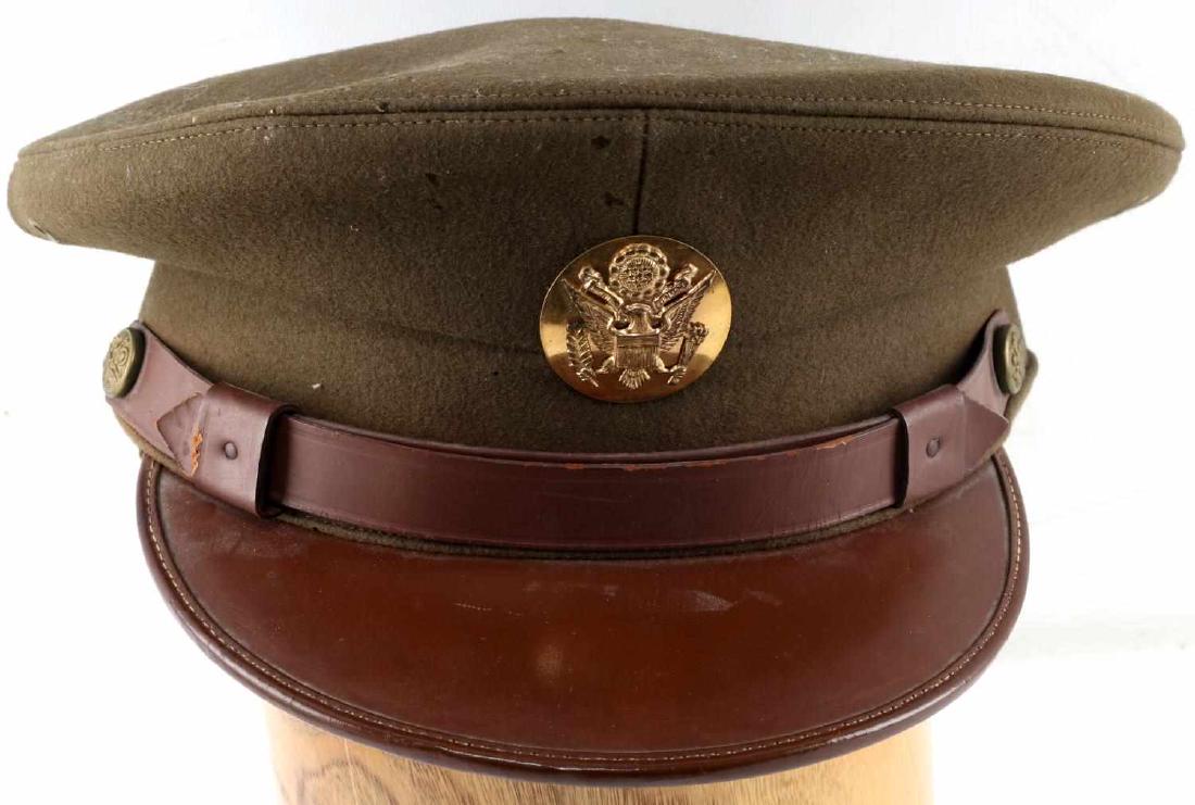 WWII US AMERICAN ARMY OFFICER PEAK VISOR CAP: US Officers visor cap. Olive green wool and leather construction. Good original chinstrap and intact cloth sweatband. Good overall with some slight mothing and leather wear present.
